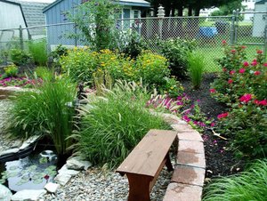 Backyard garden with brick landscape edging and small water feature