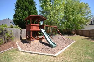 Backyard play structure with wood chips and edging